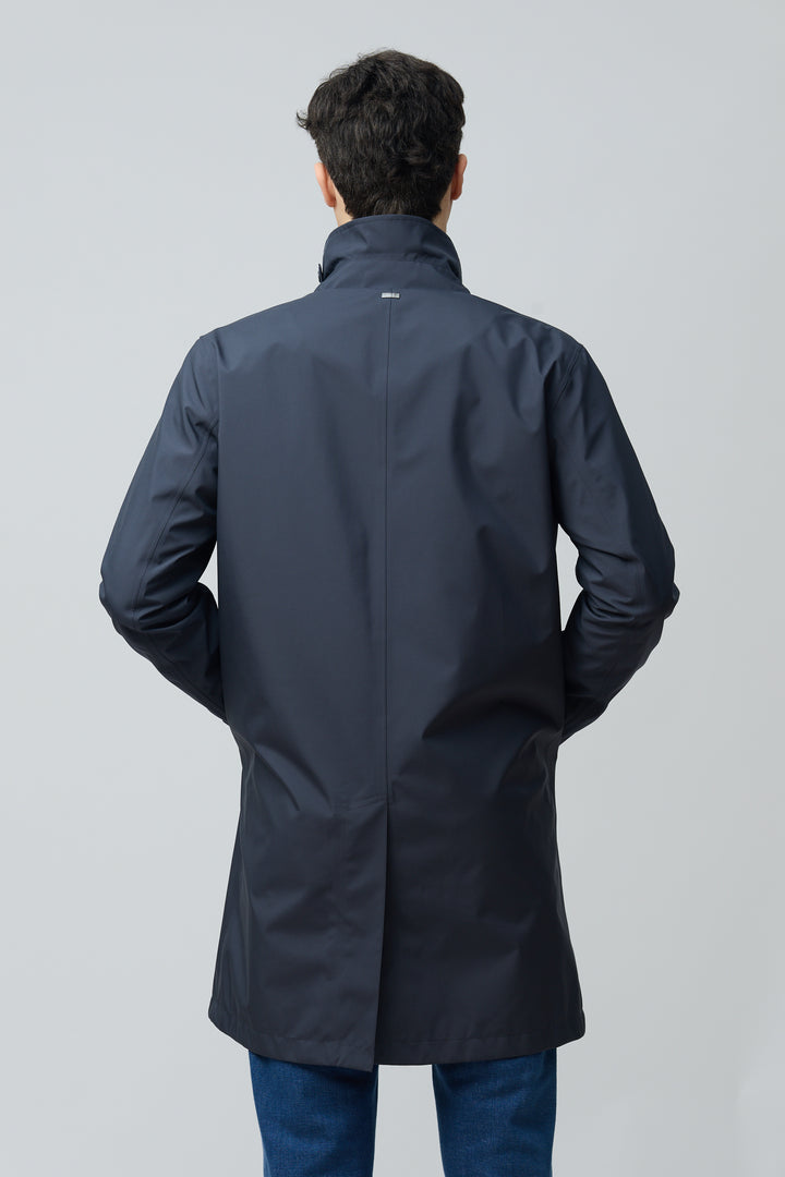 Homme portant un imperméable en microfibre technique au fini ultra-mat et coupe classique, vu de dos, avec col chemise et manches longues.