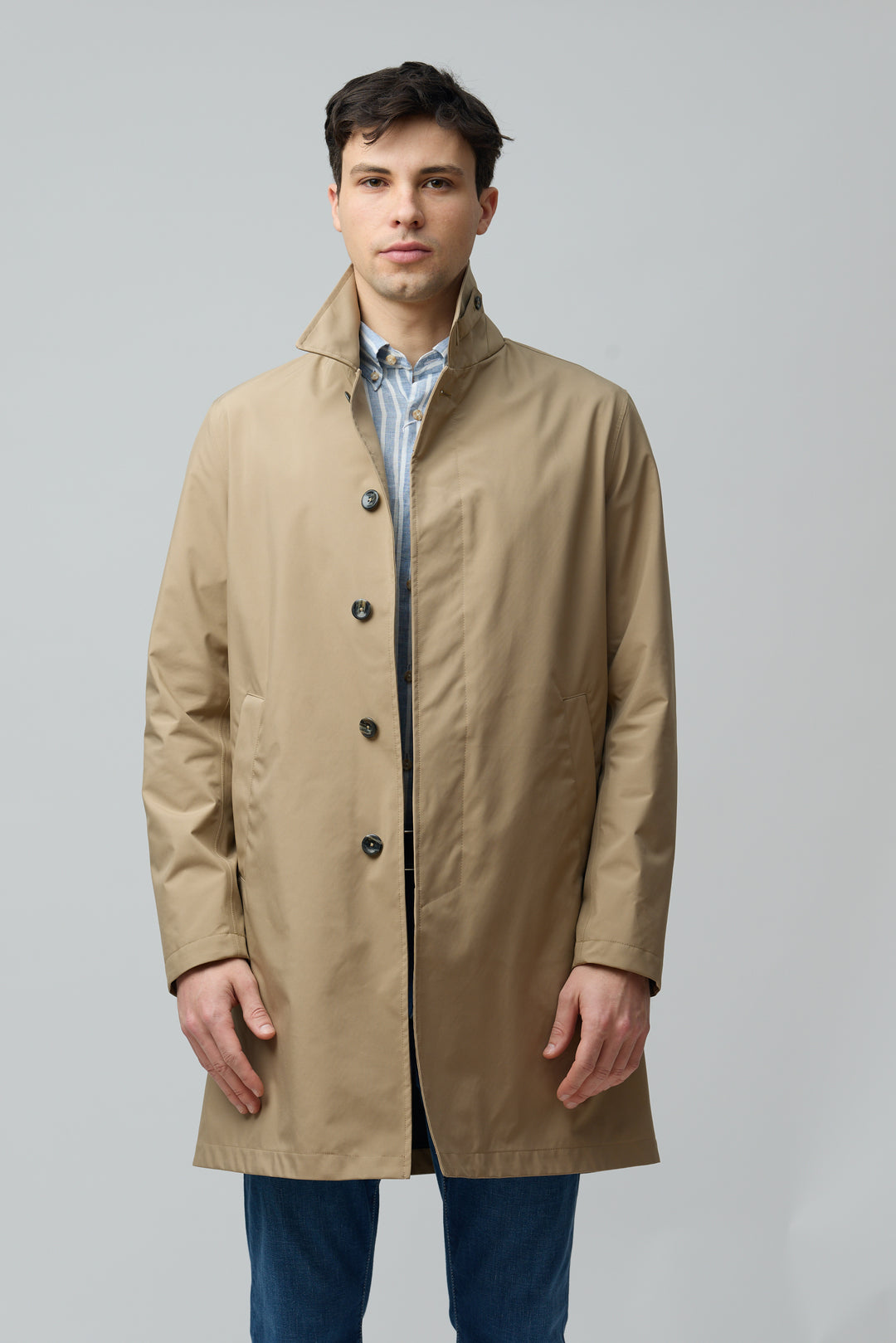 Homme portant un imperméable en microfibre technique beige à la finition ultra-mat, idéal pour la mi-saison.