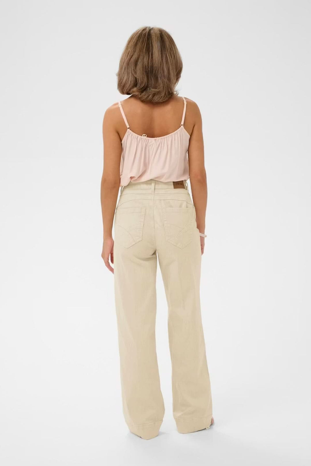 Vue arrière du Jean Tilde coupe large taille haute couleur beige, illustrant sa coupe moderne et fluide.