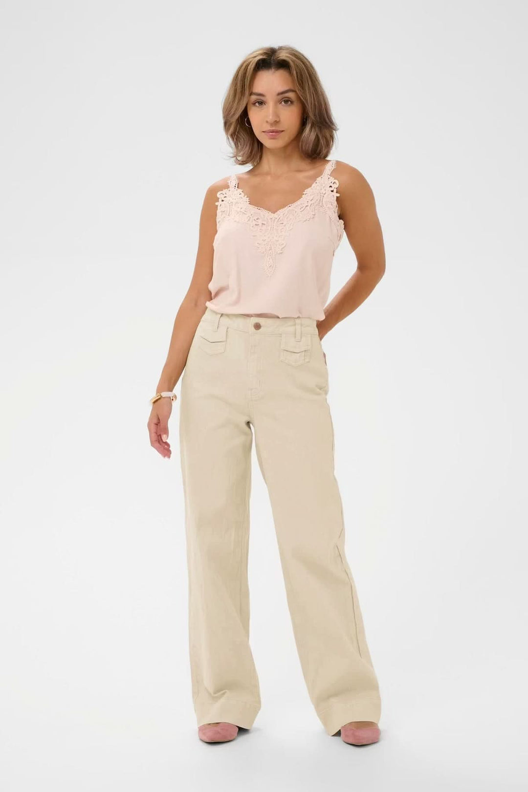 Femme portant Jean Tilde coupe large taille haute, jambes droites, poches avant, pour un style moderne et confortable.