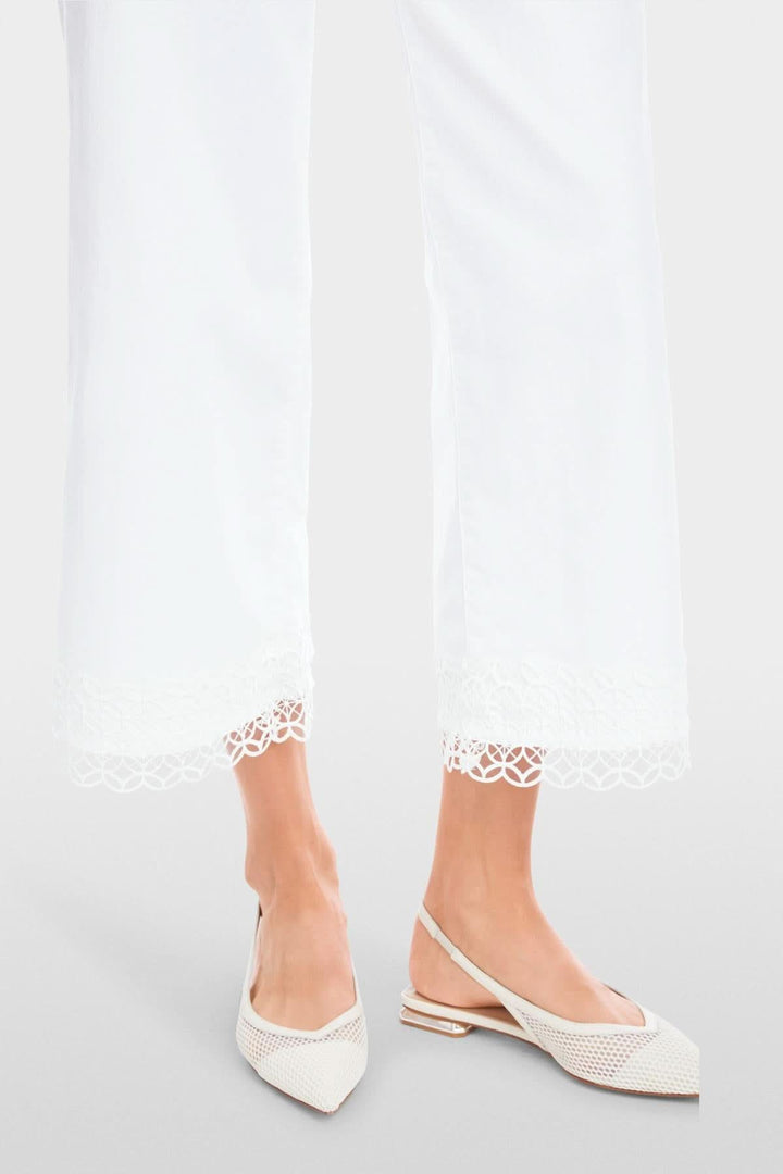 Jean Wigan avec dentelle, taille haute, ourlet délicat, porté avec des chaussures blanches, style élégant.