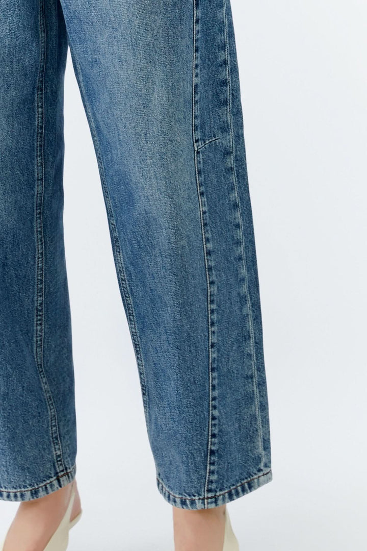 Jean baril taille haute en denim bleu avec coupe jambe arrondie pour un look contemporain et chic.