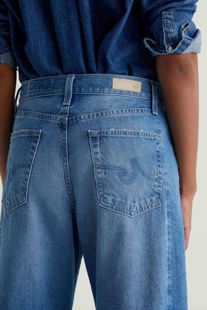 Jean droit à jambe large en denim bleu clair, vue de dos, avec poches arrière, style décontracté et moderne.