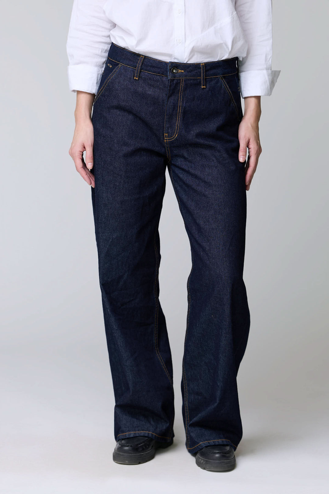 Jean à jambe large en denim brut avec coupe ample et surpiqûres contrastantes, offrant confort et style vintage.