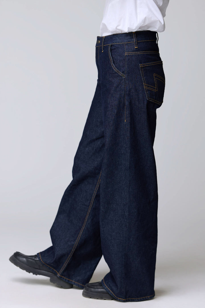 Jean à jambe large style décontracté en denim épais avec surpiqûres contrastantes et coupe ample, vue latérale.