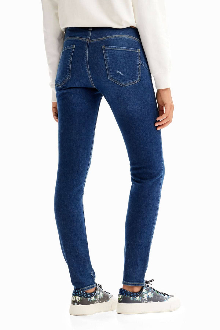 Jean skinny push-up broderies vue arrière, en denim stretch bleu avec poches et coupe ajustée.