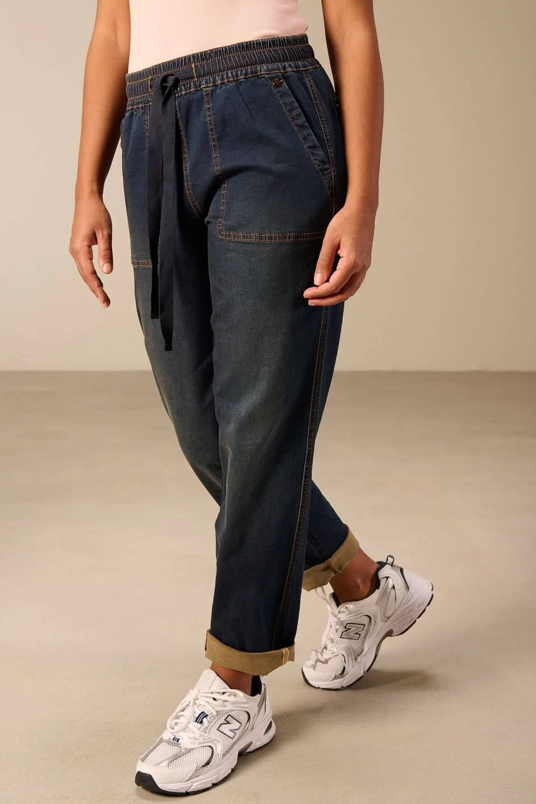 Jeanjogging à taille élastique offrant confort décontracté avec coupe fuselée et cordon ajustable, idéal pour un look casual.