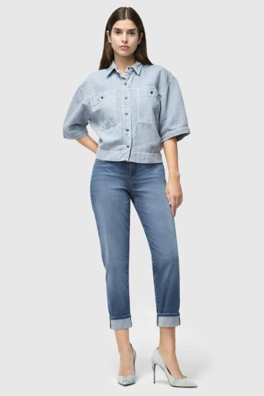 Femme en jeans Carol, silhouette féminine en denim léger, style classique avec revers, chaussure à talon.