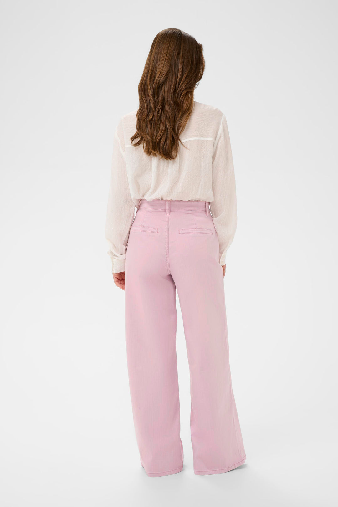 Femme portant un Jeans Visti rose à jambe large avec une blouse blanche.