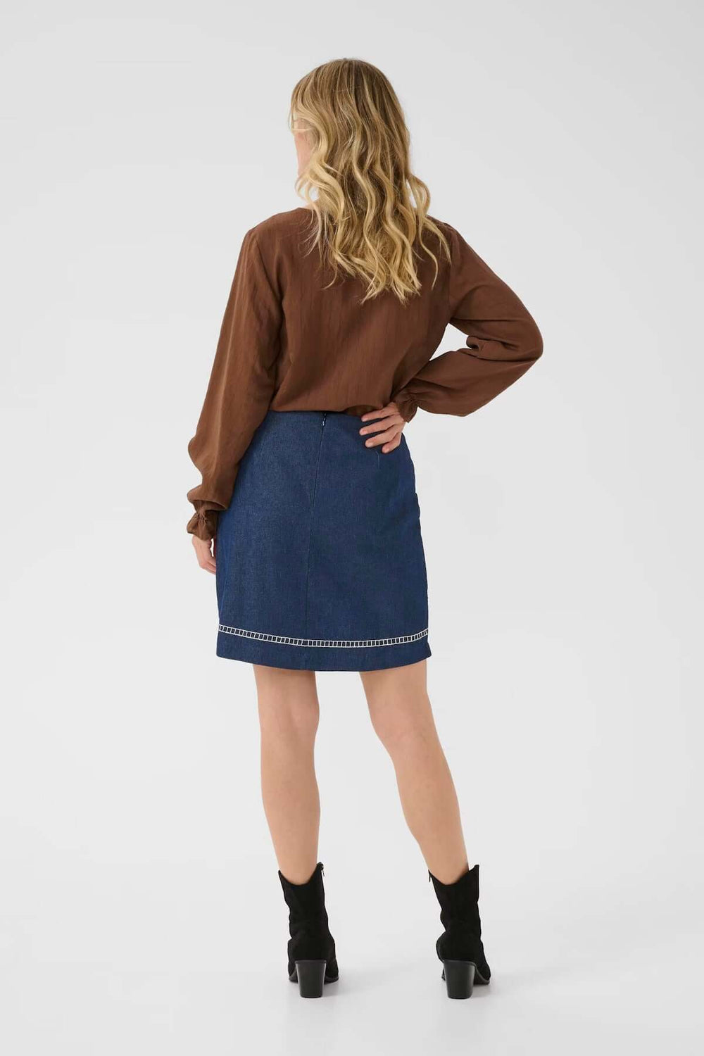 Vue arrière de la Jupe Gro en denim avec broderies florales, portée par une femme en chemisier marron.