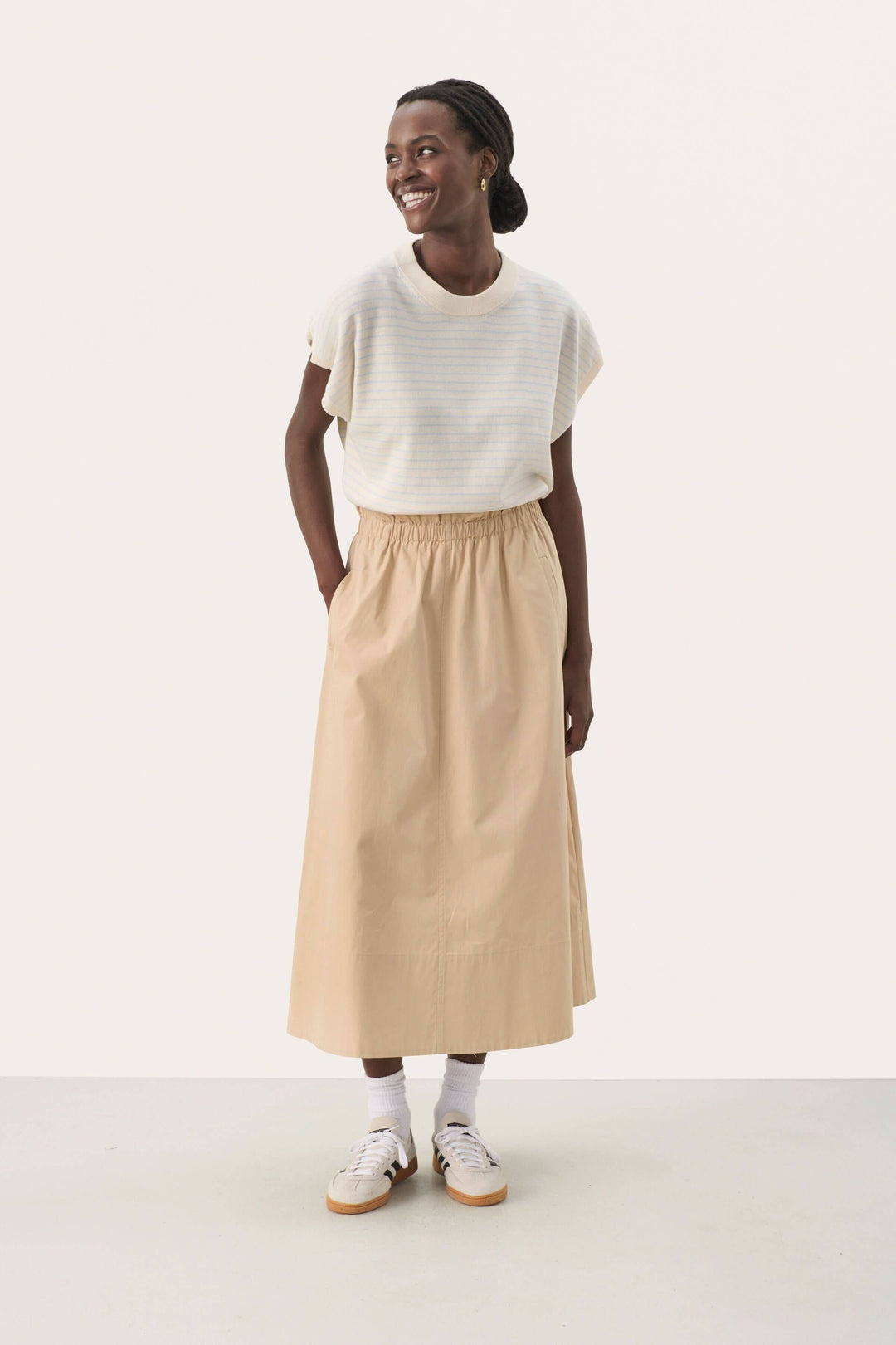 Femme souriante portant une jupe longue en coton léger, look élégant et décontracté, taille élastique.