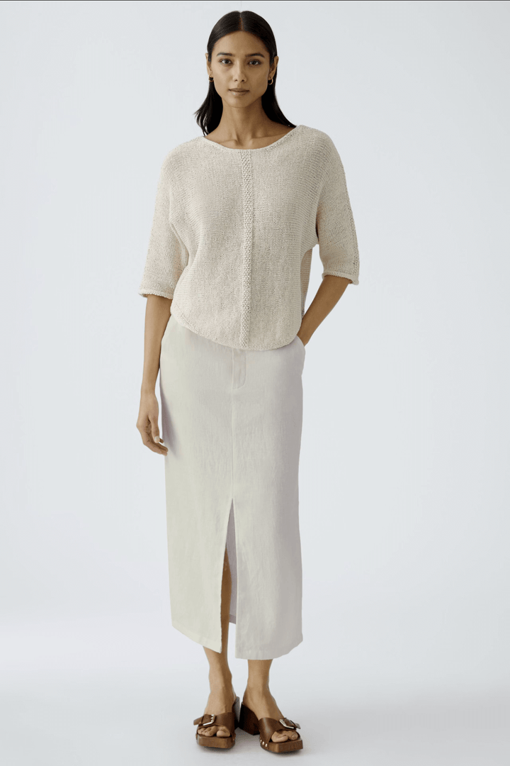 Jupe longue en lin avec poches, taille haute, fente discrète, associée à un haut décontracté, style estival.