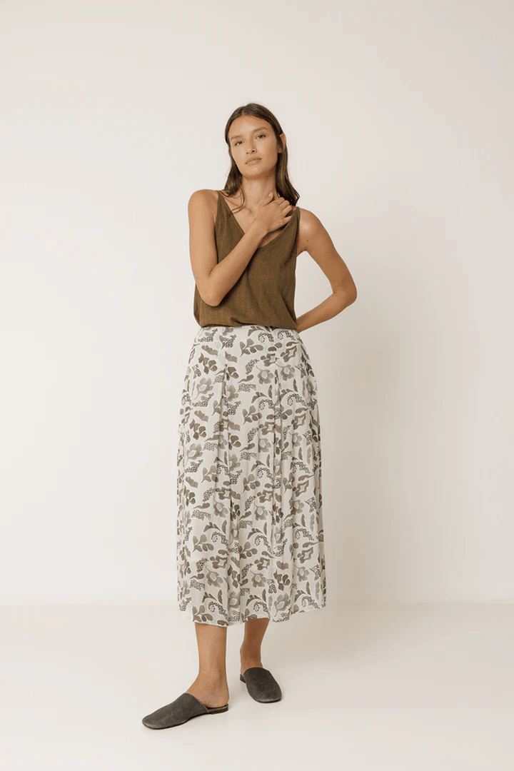 Femme portant une jupe longue imprimée fluide avec un imprimé délicat, mettant en valeur une silhouette élégante et naturelle.