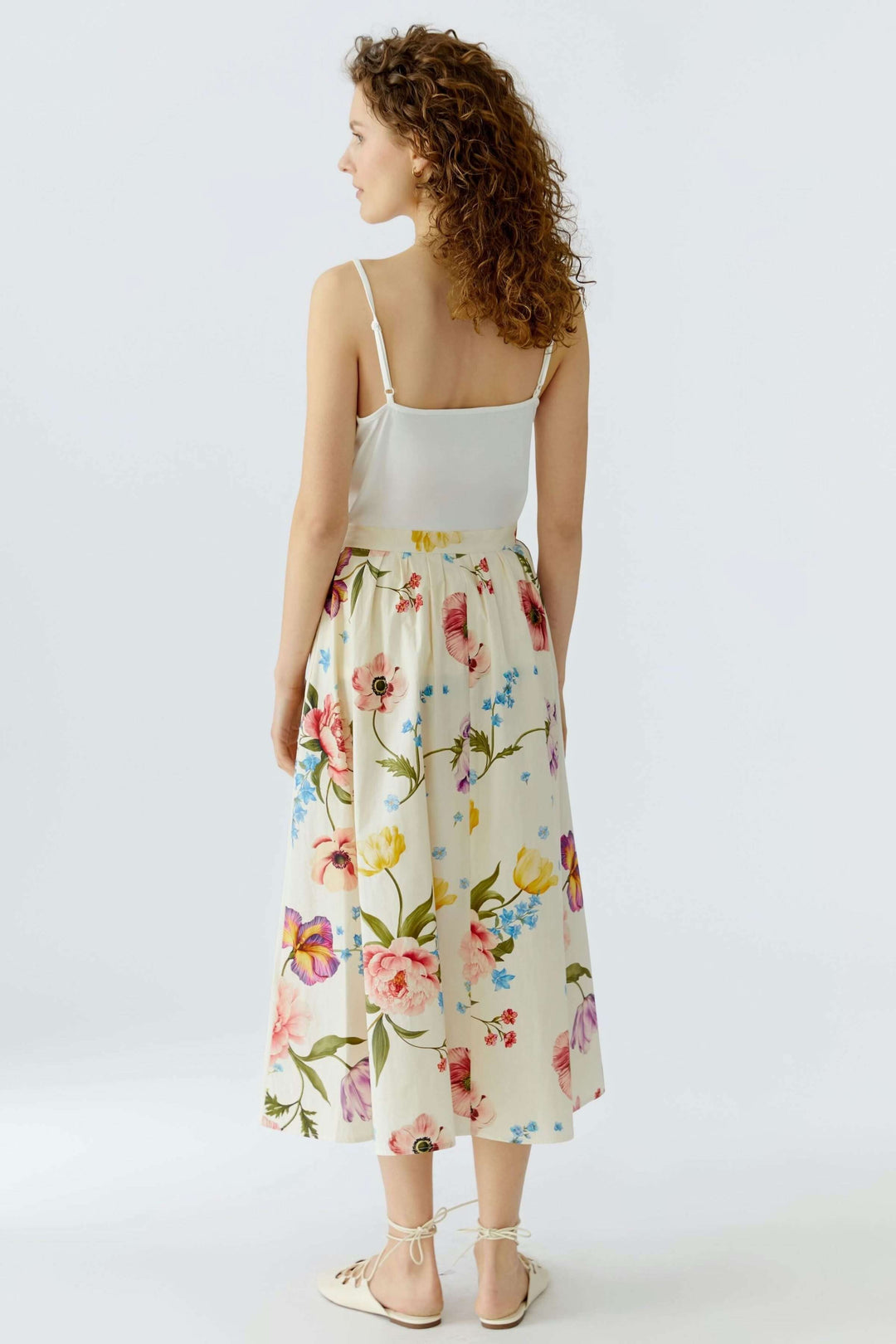 Jupe mi-longue imprimé de fleurs délicat, silhouette fluide et coupe évasée pour un look élégant et confortable.