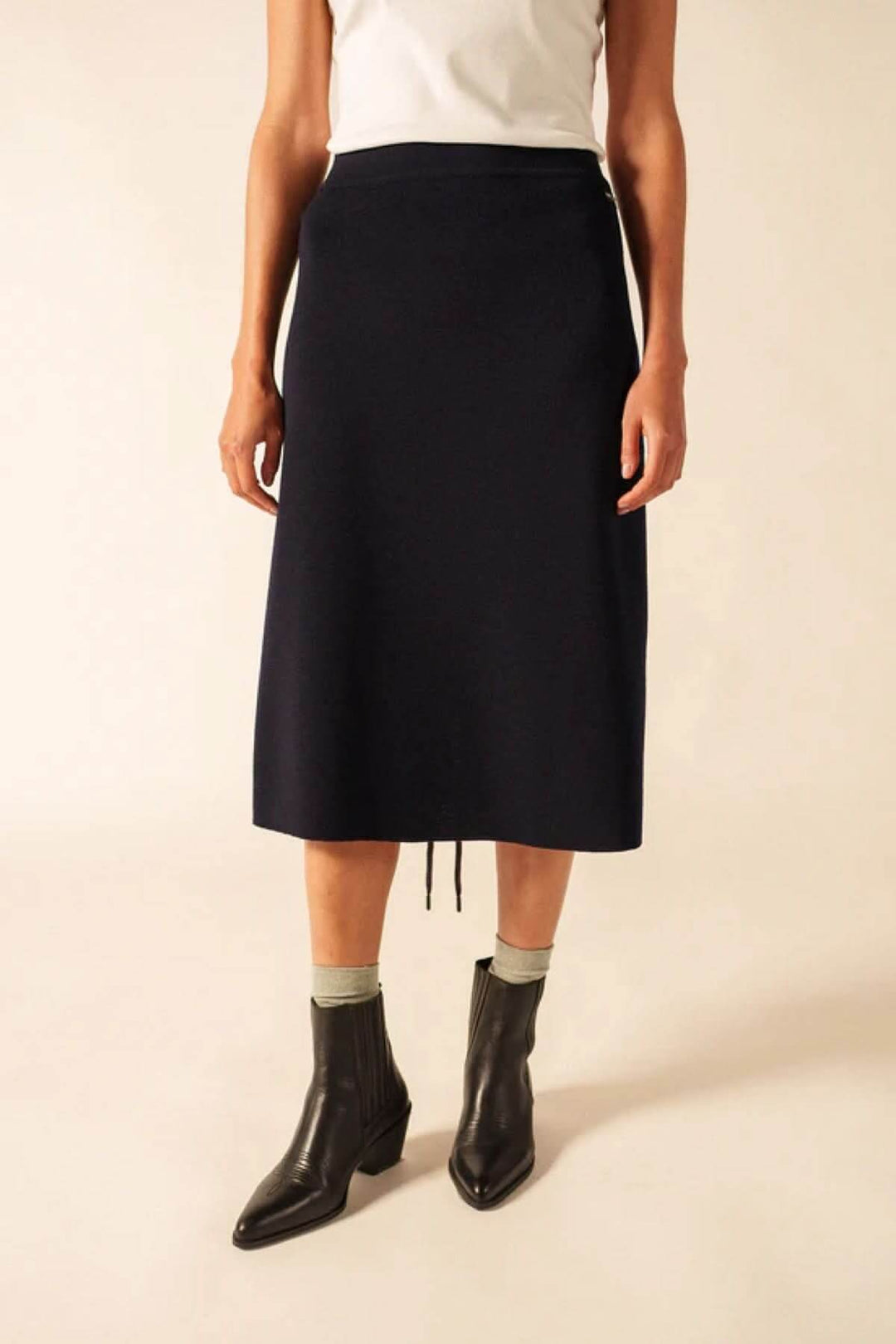 Jupe midi en laine simple, élégante et fluide, souligne la féminité avec une coupe évasée et élastique, parfaite pour toute occasion.