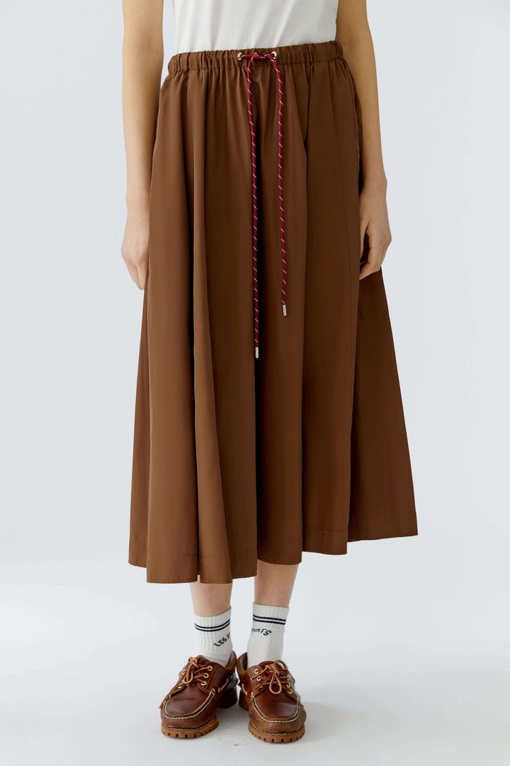 Jupe midi fluide marron avec taille élastique et cordon ajustable, parfaite pour une silhouette moderne et confortable.