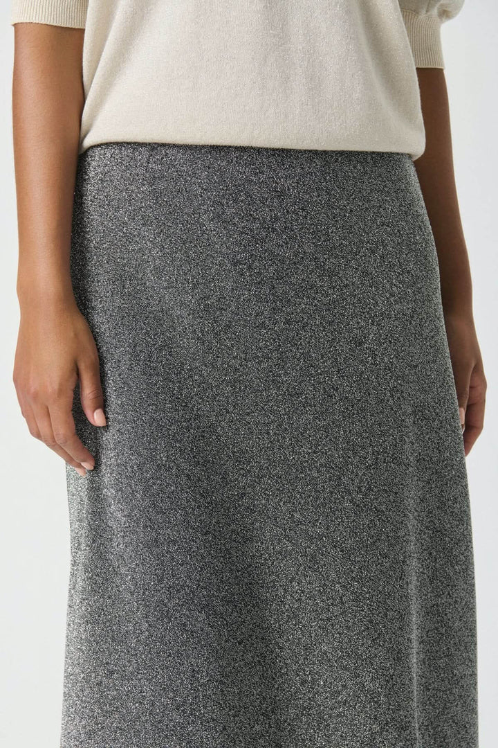 Femme portant la Jupe scintillante Viebe avec effet métallisé et coupe évasée, idéale pour les occasions festives.