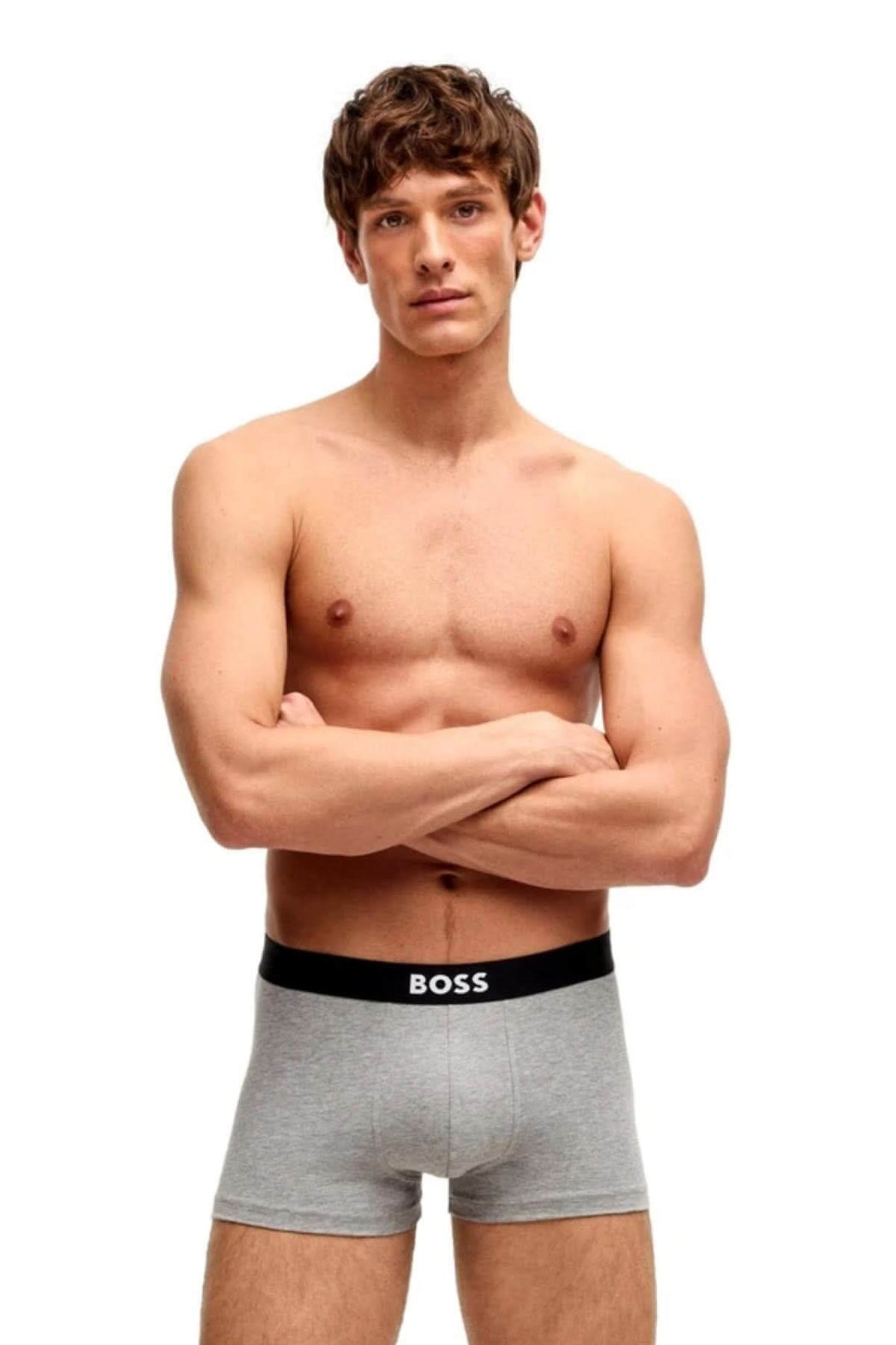Homme portant un boxer court gris BOSS avec ceinture élastique noire, mettant en avant confort et style.