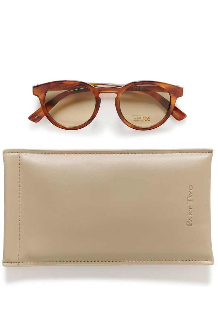 Lunette de soleil Nino avec monture arrondie en acétate effet écaille et verres teintés, accompagnée d&