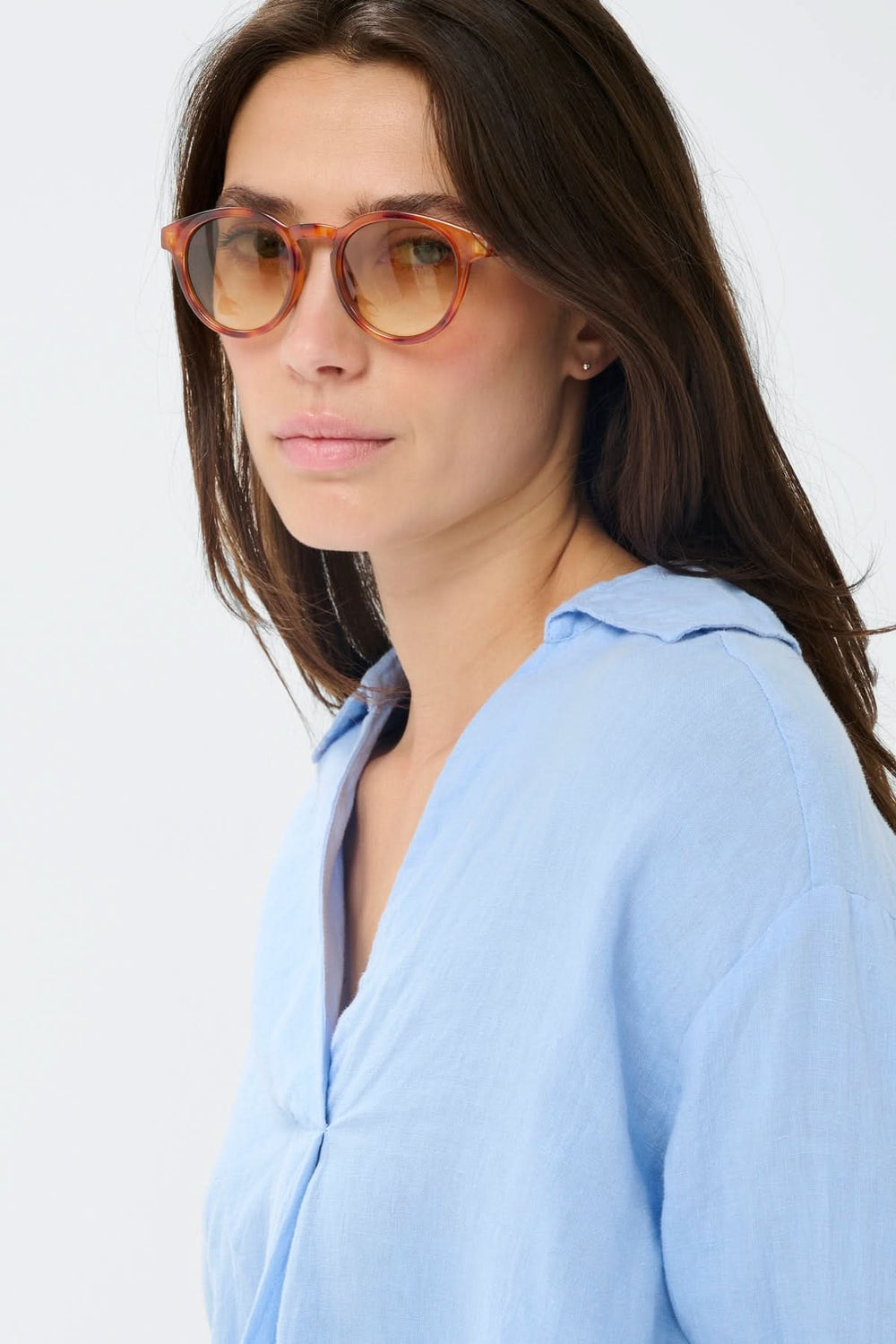 Femme portant des Lunette de soleil Nino au design arrondi en acétate effet écaille avec verres teintés pour un style élégant.