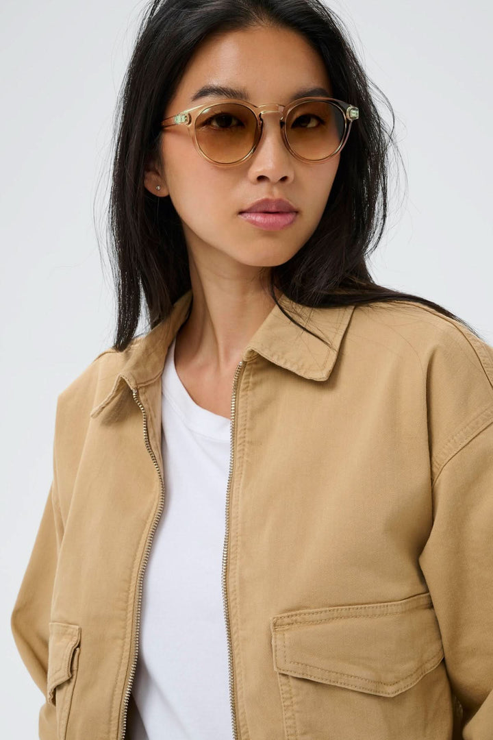 Femme portant des Lunette de soleil Nino au design arrondi, monture effet écaille et verres teintés élégants.