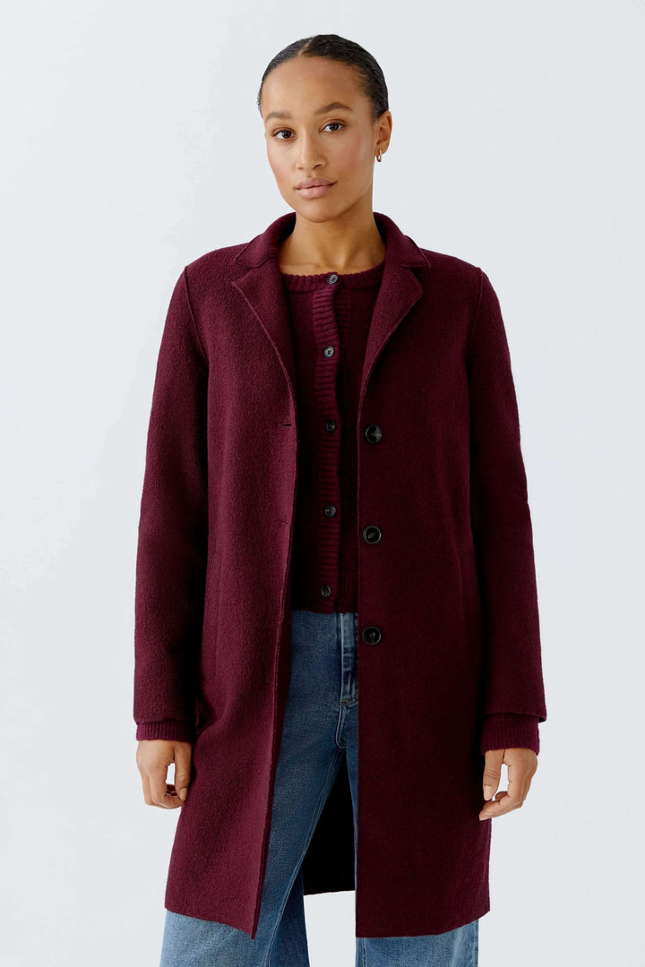 Manteau Mayson en bordeaux, coupe droite, style élégant, porté sur un chandail et jean pour un look chic.