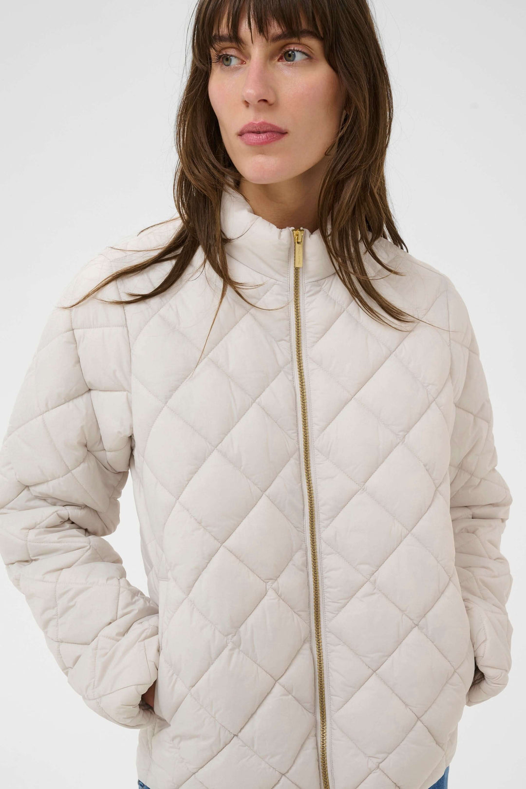 Femme portant un Manteau Olia matelassé, coupe droite et col montant, confortable pour les journées fraîches.