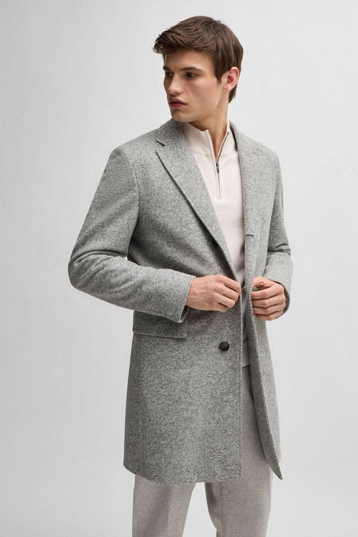 Manteau à chevrons gris pour homme, coupe ajustée, avec fermeture amovible, style élégant et moderne.