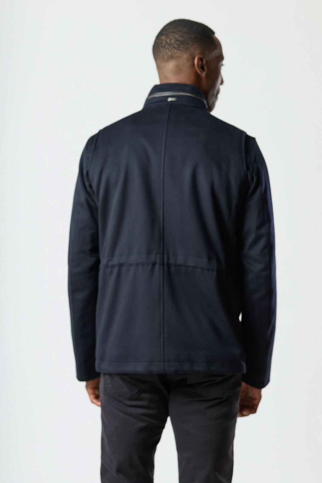 Vue arrière du manteau en laine à quatre poches, homme portant une veste structurée avec col montant et coupe droite.