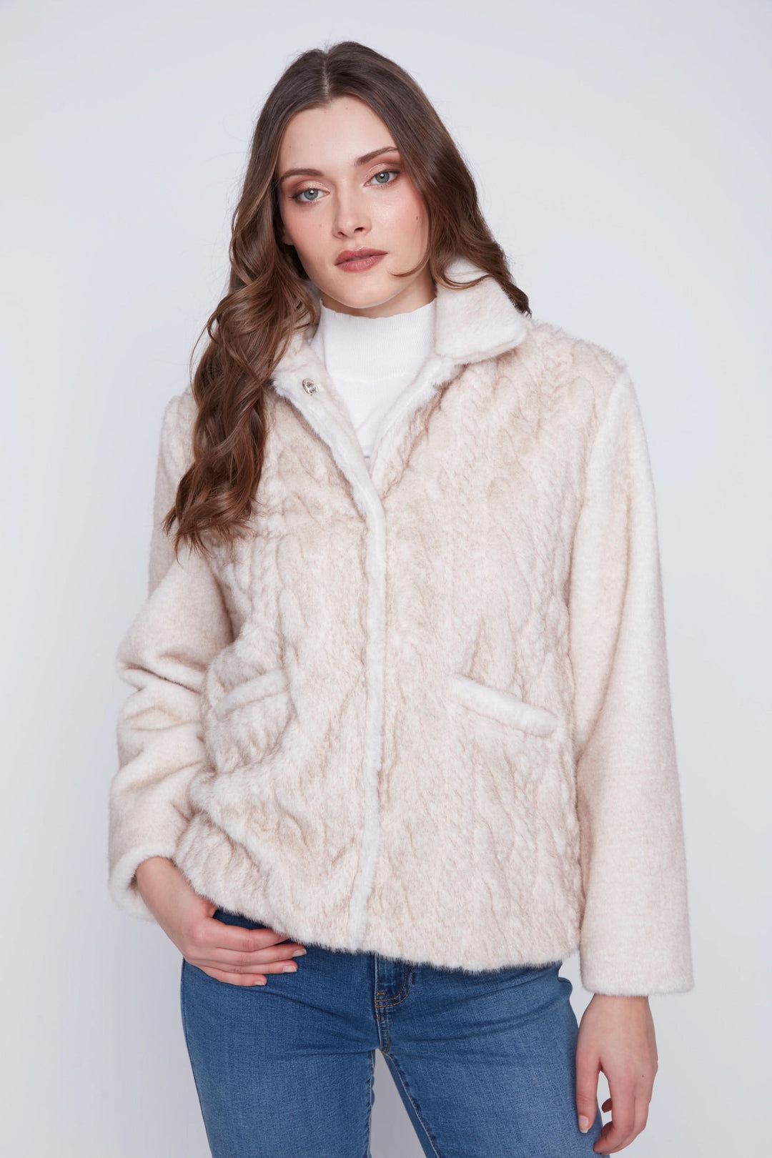 Manteau fausse fourrure doux et élégant avec col classique, porté sur un jean pour un look chic.