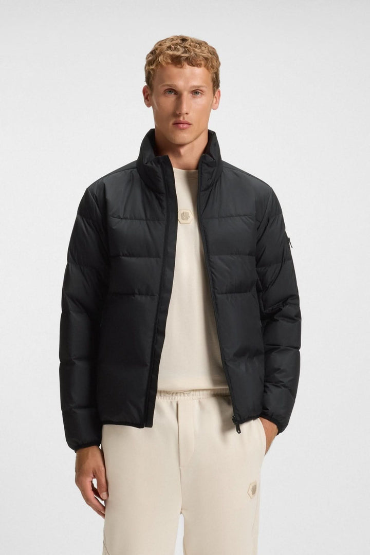 Homme portant un manteau matelassé déperlant en duvet avec poche sur la manche, idéal pour la mi-saison.