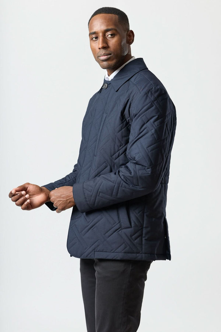 Homme portant le manteau matelassé technique marine avec motif géométrique et tissu déperlant.