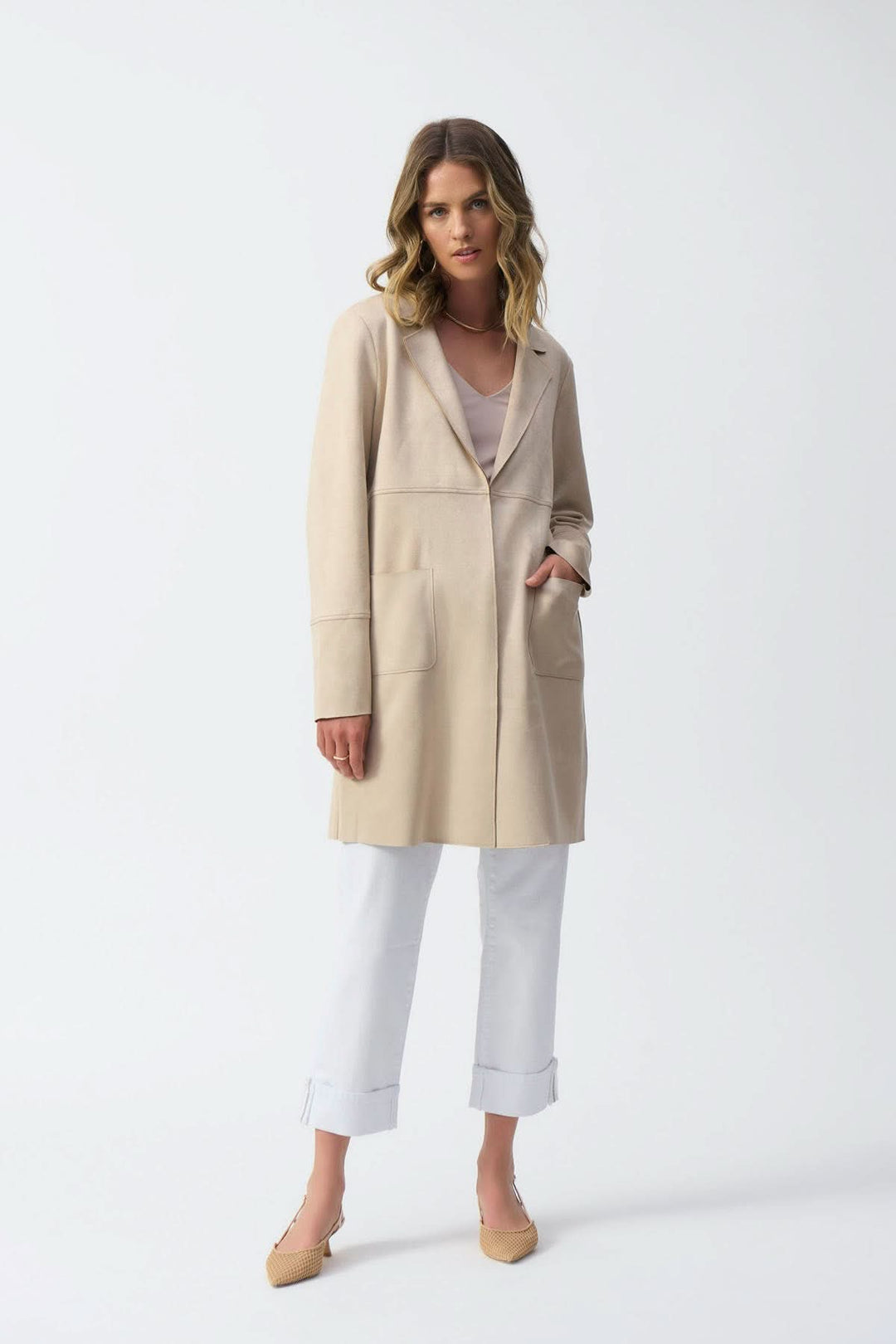 Manteau mi-long beige avec col cranté, poche avant, porté par un mannequin sur fond blanc.
