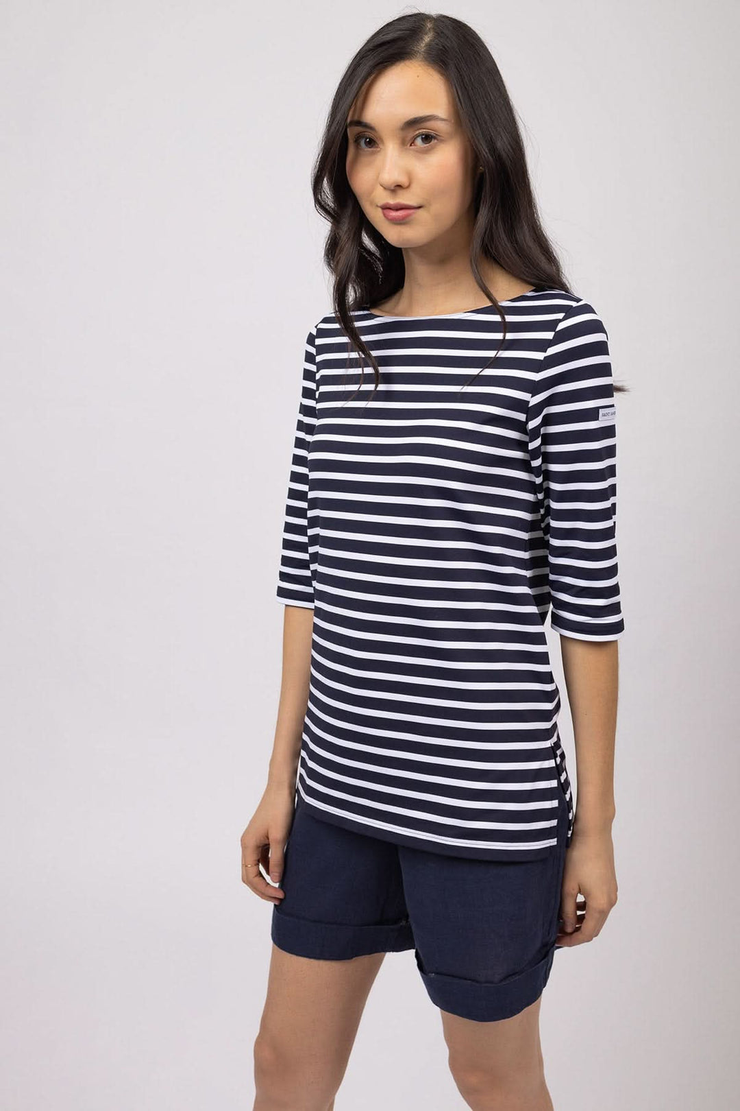 Femme portant une Marinière à col bateau PHARE à rayures avec manches trois-quarts, offrant une silhouette épurée et élégante.