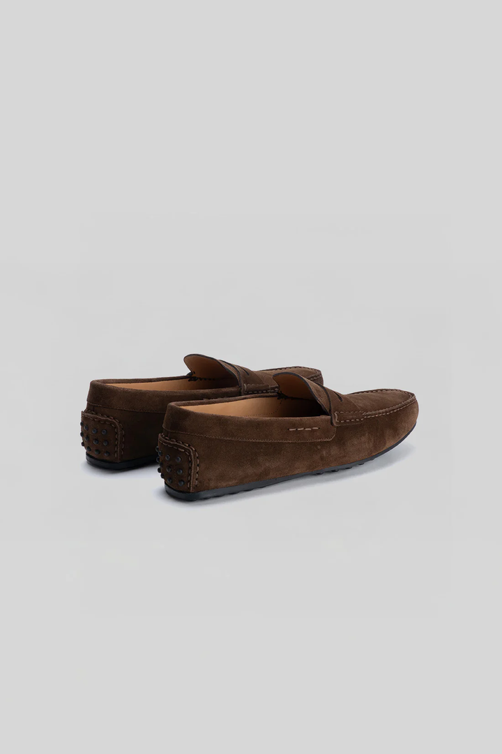 Mocassin Conor en suède marron, confectionné en Italie, avec doublure en cuir de veau et semelle coussinée pour un confort optimal.