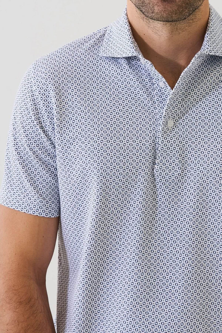 Homme portant un POLO IMPRIMÉ À MANCHES COURTES avec un motif géométrique subtil et tissu extensible, couleur discrète et élégante.