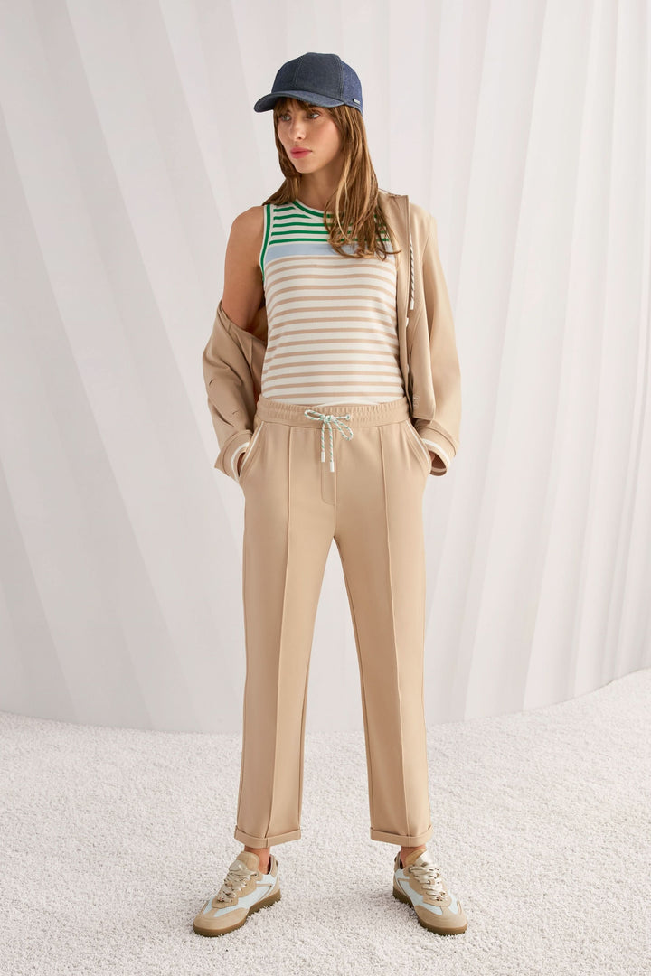 Femme portant le Pantalon FRIA à enfiler en mélange de coton avec taille élastique et cordon, look casual chic associé à un débardeur.