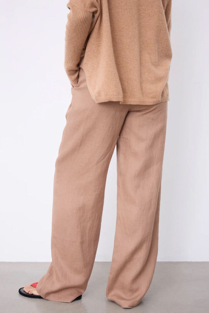 Pantalon Paula large fluide taille haute pour un look chic décontracté avec coupe fluide et confort absolu, montre un style élégant.