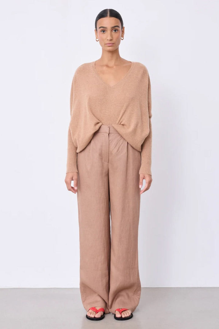 Pantalon Paula large fluide taille haute, élégant et confortable, porté avec un tricot léger, idéal pour un style chic décontracté.