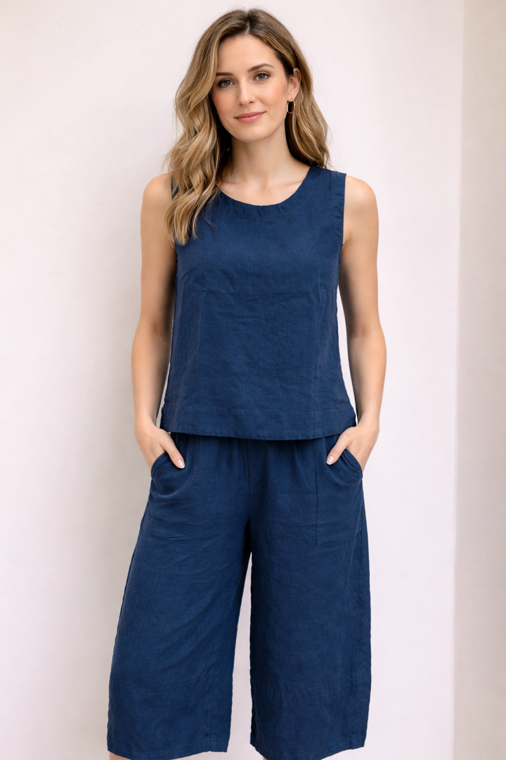 Femme portant un pantalon ample en lin à taille élastique, coupe décontractée avec poches latérales, couleur bleu foncé.