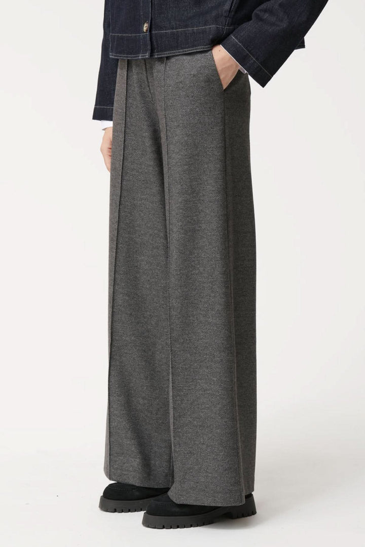 Pantalon ample à la coupe fluide gris, avec taille élastique et plis marqués, pour un look élégant et confortable.