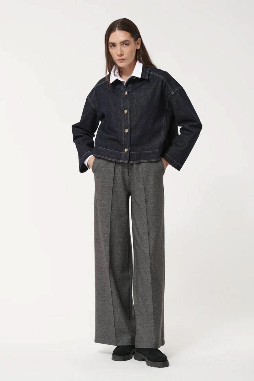 Femme portant un pantalon ample à la coupe fluide avec une veste en jean, alliant confort et modernité.