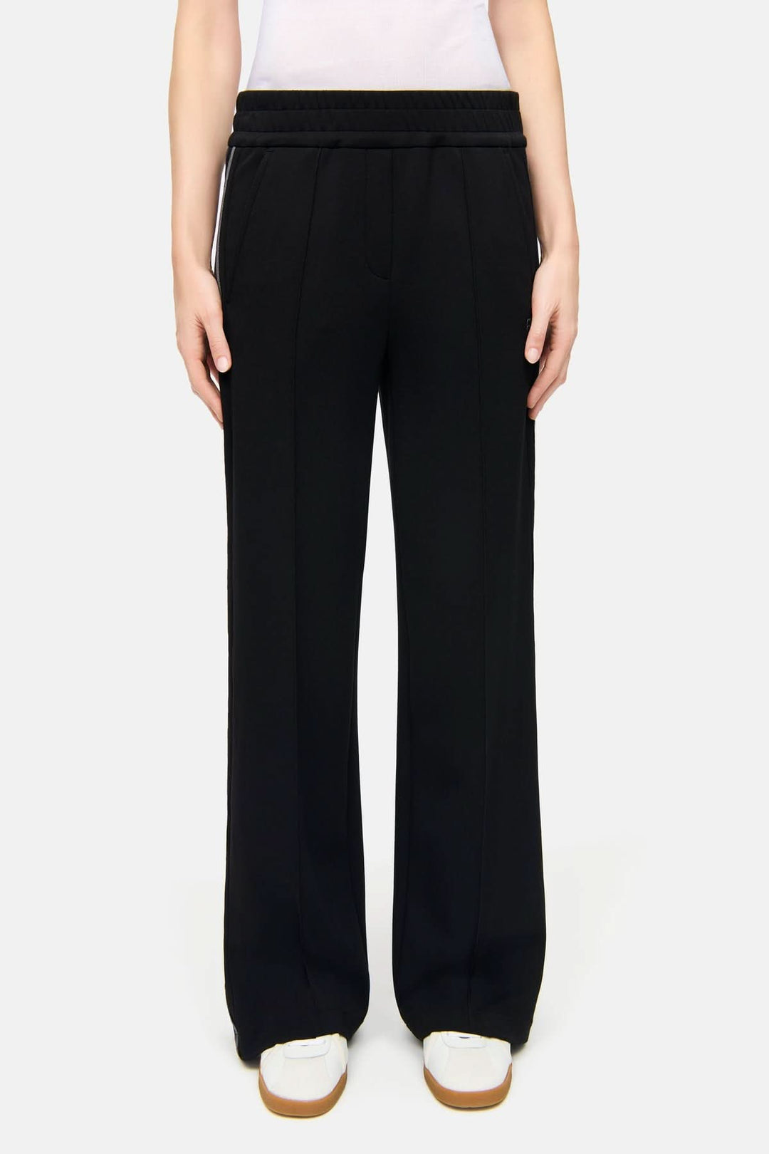Pantalon à bandes latérales Amelia noir avec design moderne, tissu fluide et taille élastique pour un confort optimal.