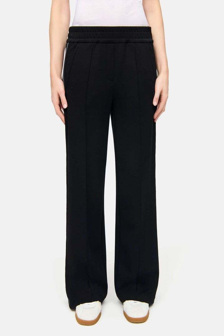 Pantalon à bandes latérales Amelia noir avec design moderne, tissu fluide et taille élastique pour un confort optimal.