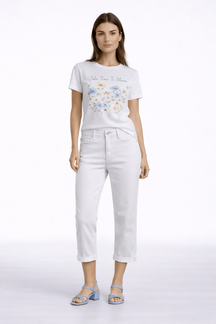 Femme portant un pantalon capri ajusté et un t-shirt imprimé, look moderne et épuré.
