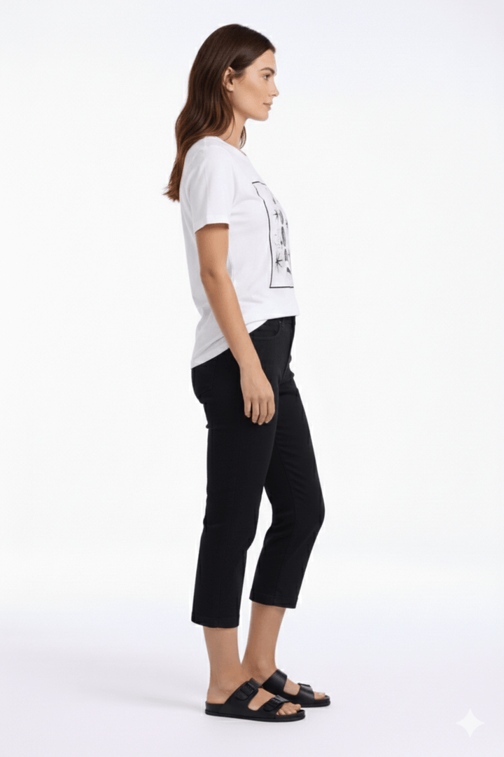 Femme portant un pantalon capri ajusté noir, mettant en valeur une silhouette moderne et épurée. Longueur au mollet, style confortable.