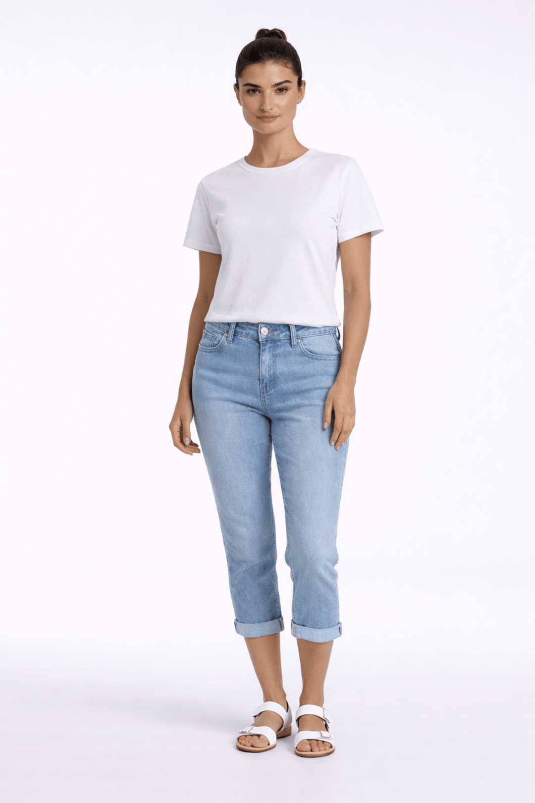 Pantalon capri ajusté en denim bleu, confort et style moderne pour une tenue quotidienne casual avec t-shirt blanc et sandales.