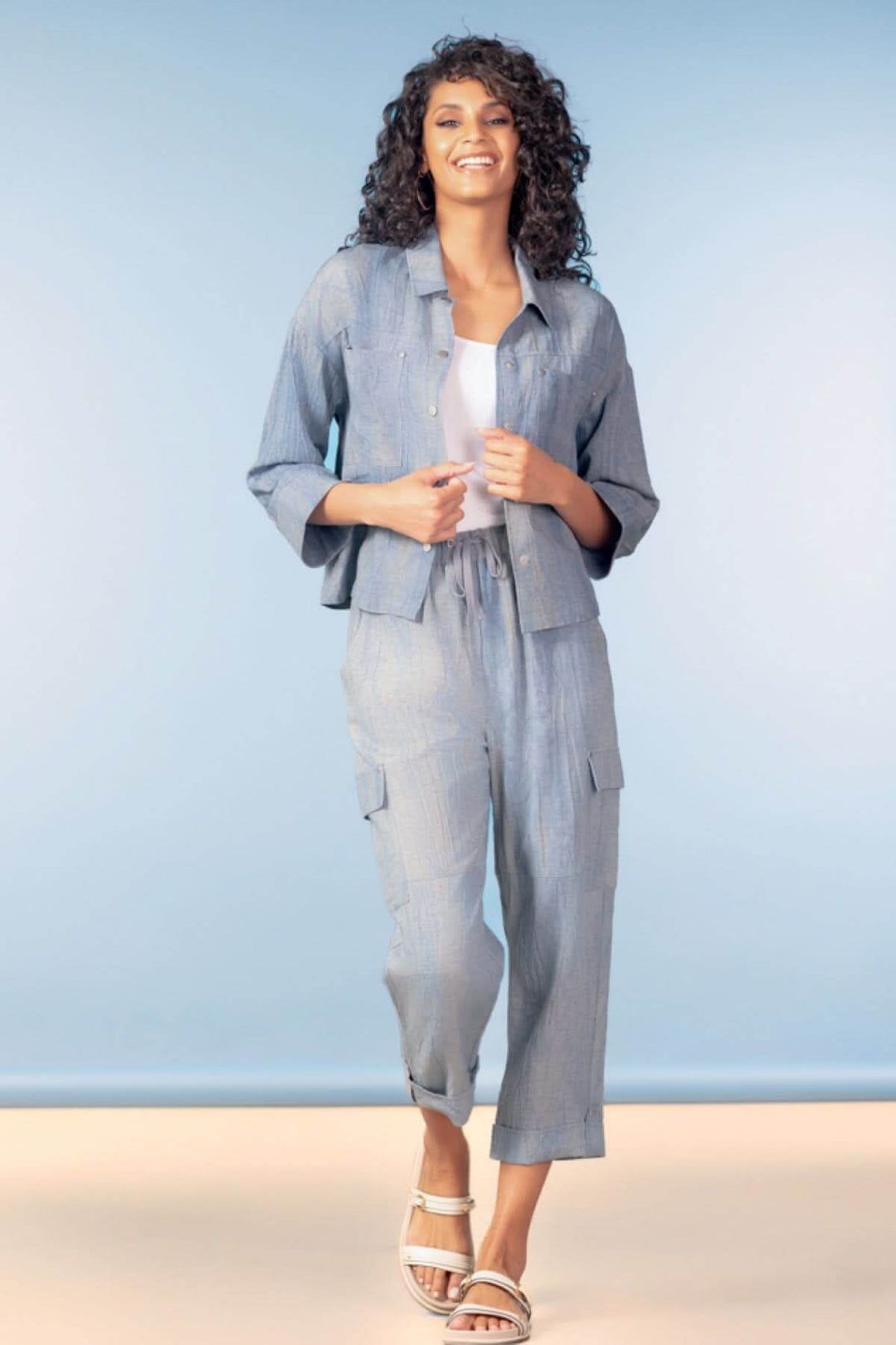 Pantalon cargo longueur cheville en tissu léger bleu porté avec une veste assortie, idéal pour un look décontracté et moderne.