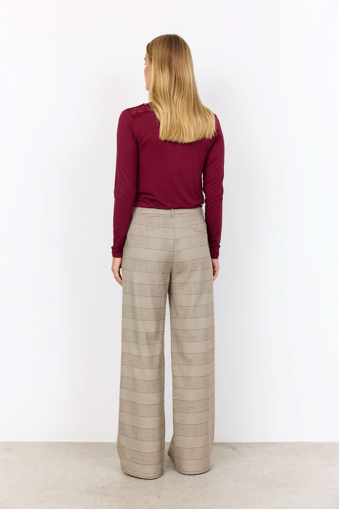 Femme portant pantalon à carreaux coupe large, avec motif prince-de-galles, vue de dos.