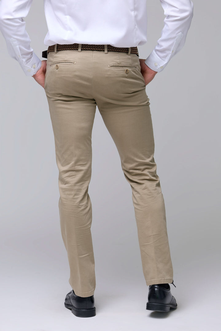 Homme portant un pantalon chino ajusté beige avec poches arrière, offrant un look professionnel décontracté.